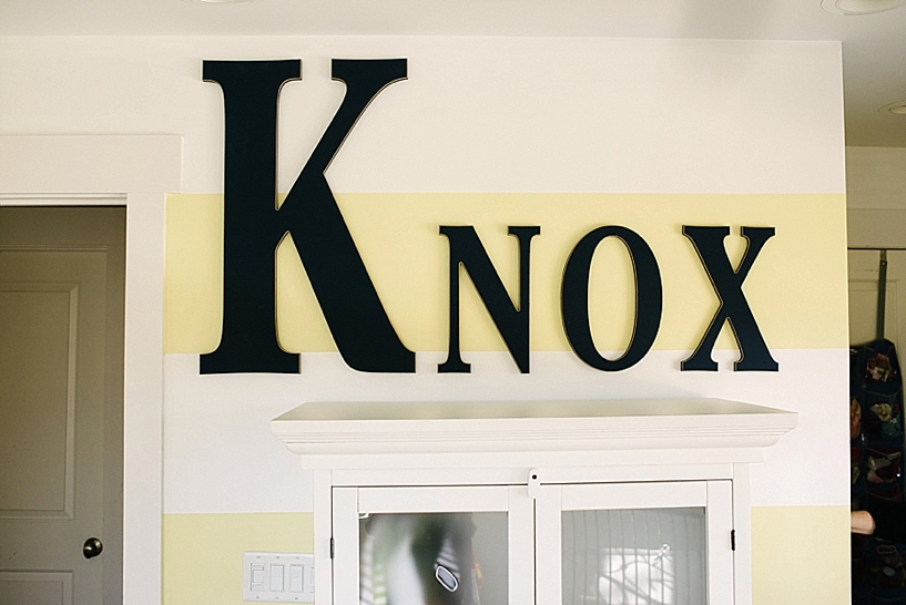 yellow striped bedroom wall with Knox spelled out in wooden letters