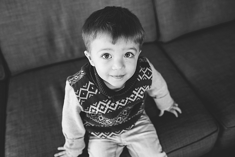 toddler boy wearing sweater vest sitting on couch