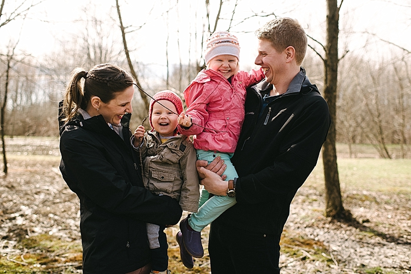 parents holding young kids in their arms and laughing