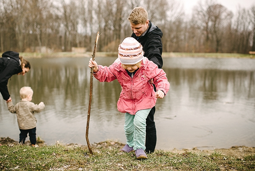 parents with young kids looking at pond