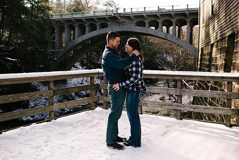 couple standing in front of Lanterman's Mill in the winter