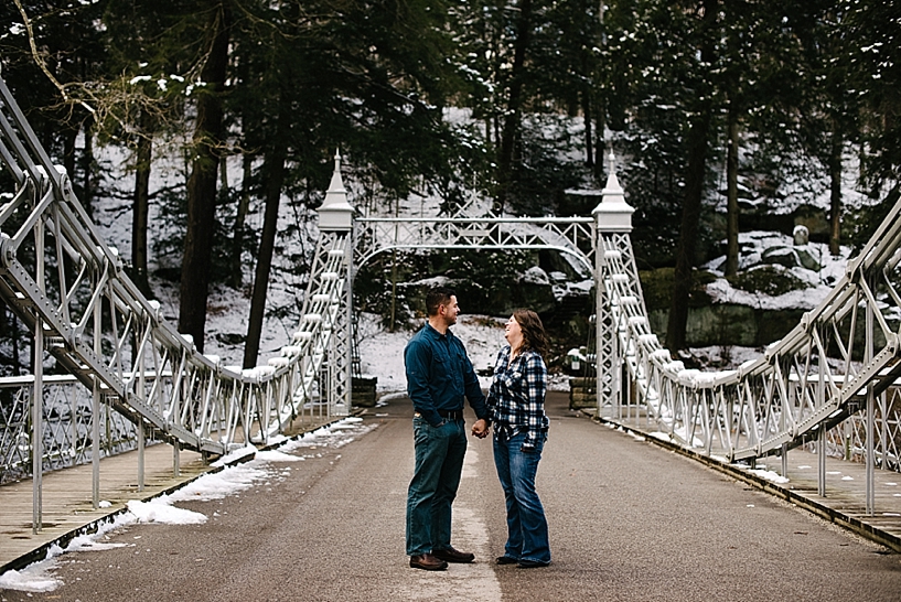 couple holding hands standing under Cinderella Bridge in Mill Creek Park