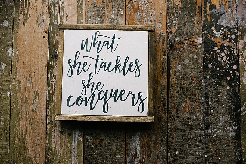 What She Tackles She Conquers handlettered wooden sign