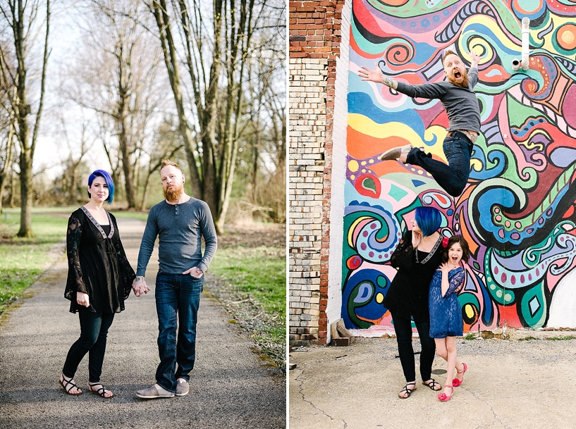 Man jumping over wife and daughter standing in front of colorful mural on brick building
