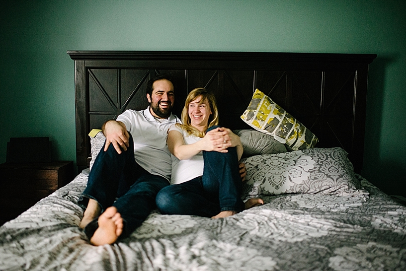 couple sitting on bed with gray comforter