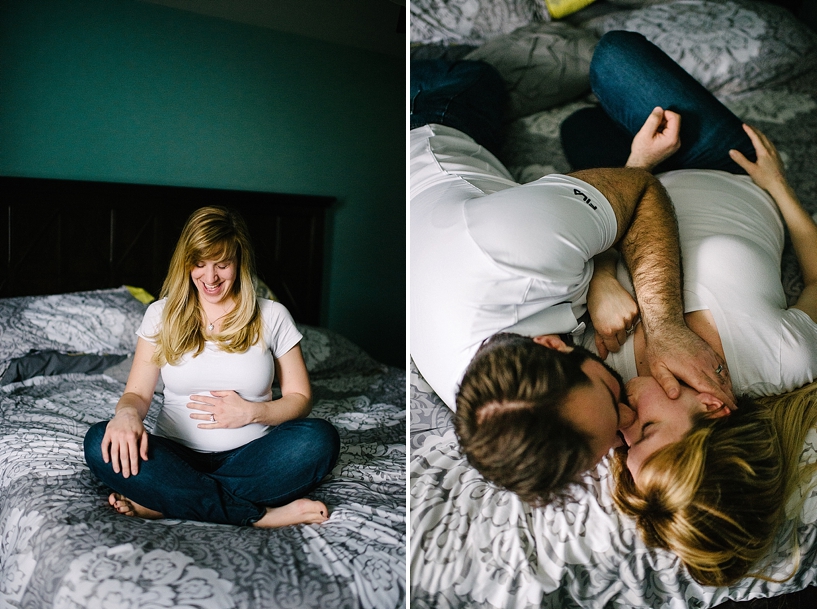 pregnant woman wearing white shirt sitting on bed with hands on her belly