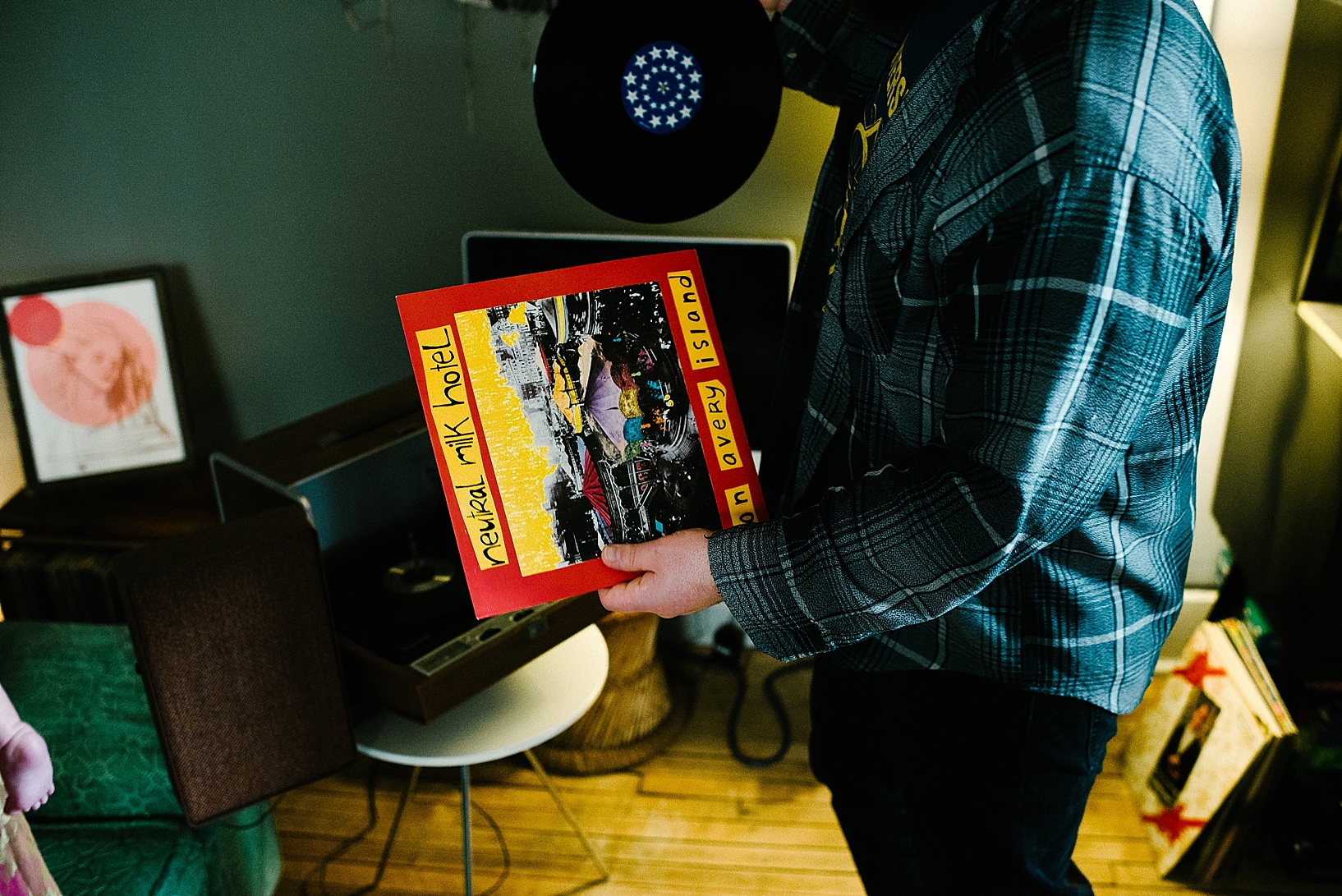 man pulling out Neutral Milk Hotel vinyl to put on record player