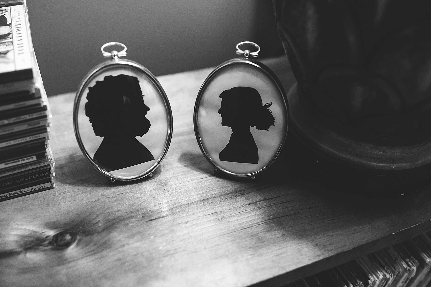 framed silhouettes of man and woman on bookcase