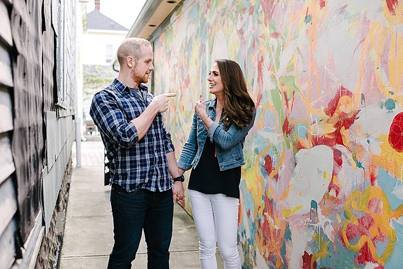 couple standing in front of colorful mural