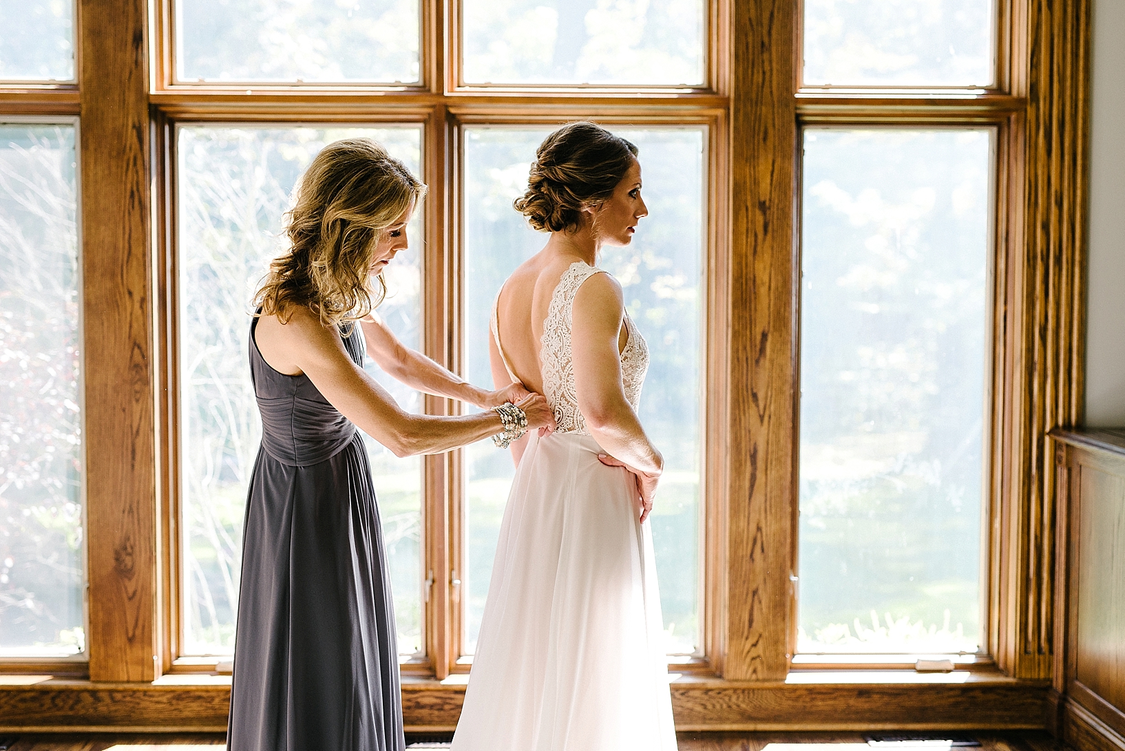 mother of the bride helping daughter into BHLDN wedding dress