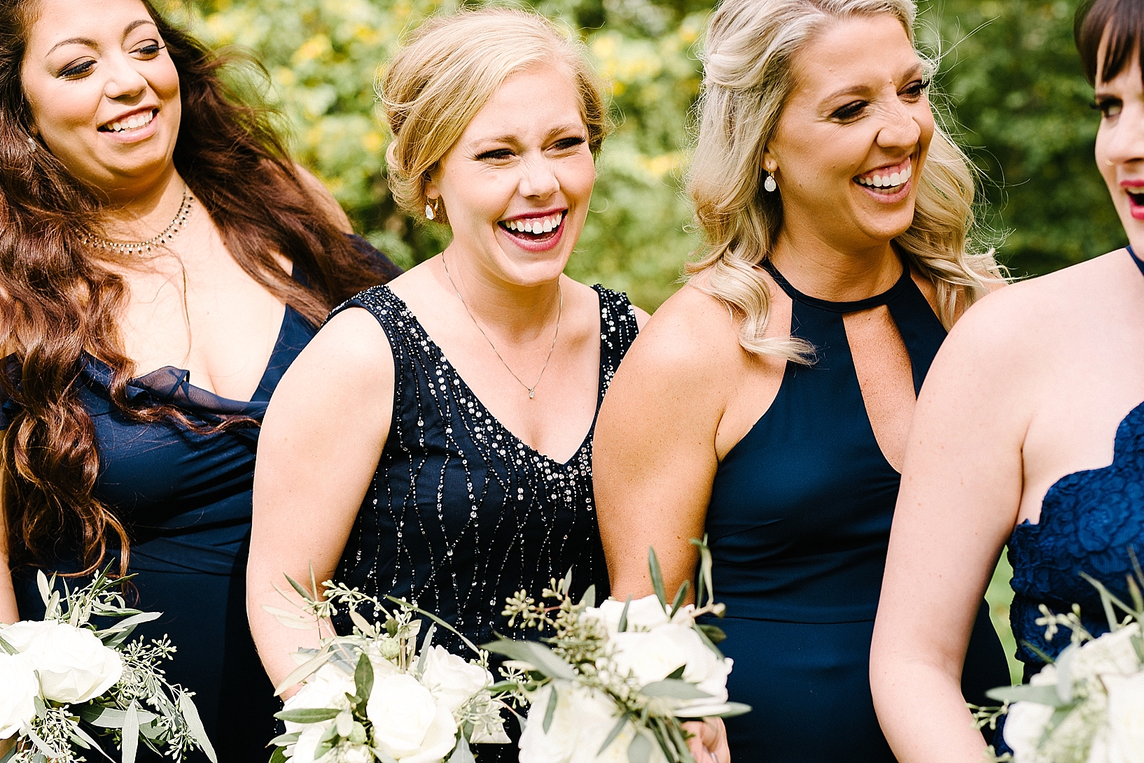 bridesmaids wearing navy dresses laughing