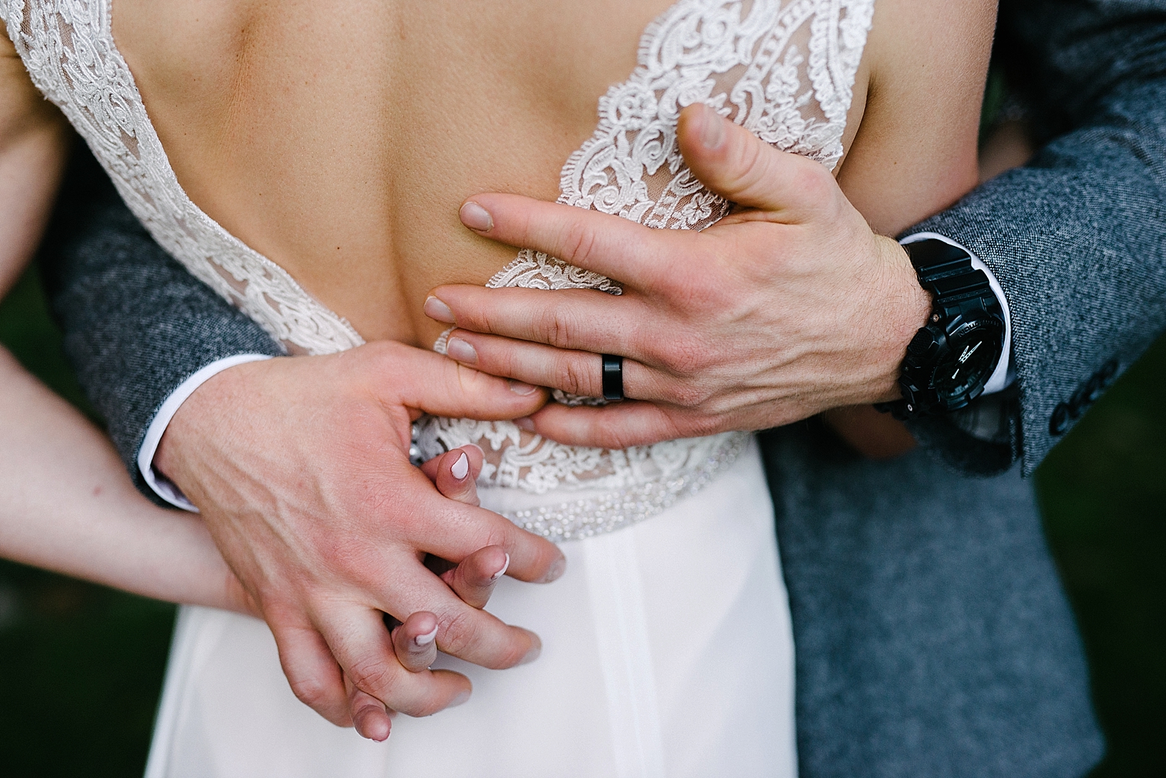 groom's hands wrapped around his bride