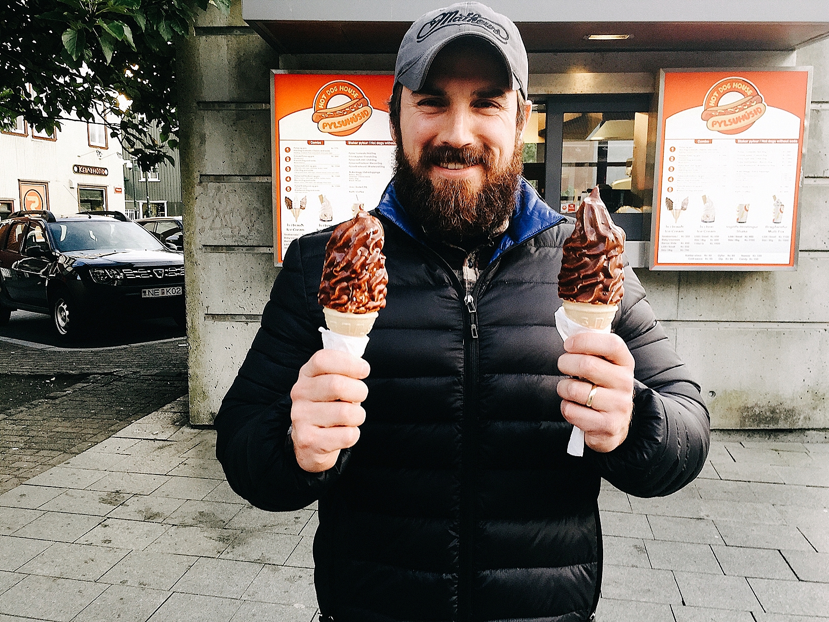 man holding chocolate dipped ice cream cones in Reykjavik Iceland