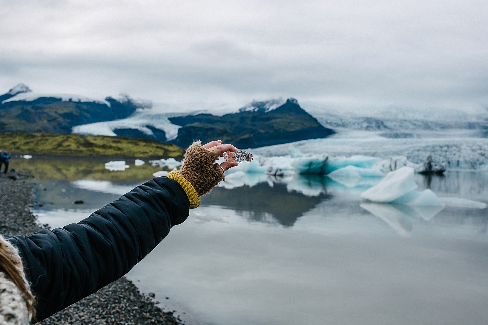 woman holding small piece of iceberg in hand Jokulsarlon Iceland