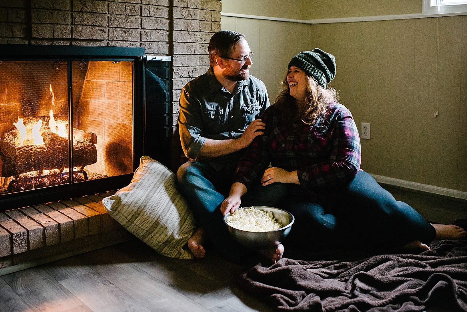 couple sitting by fireplace 