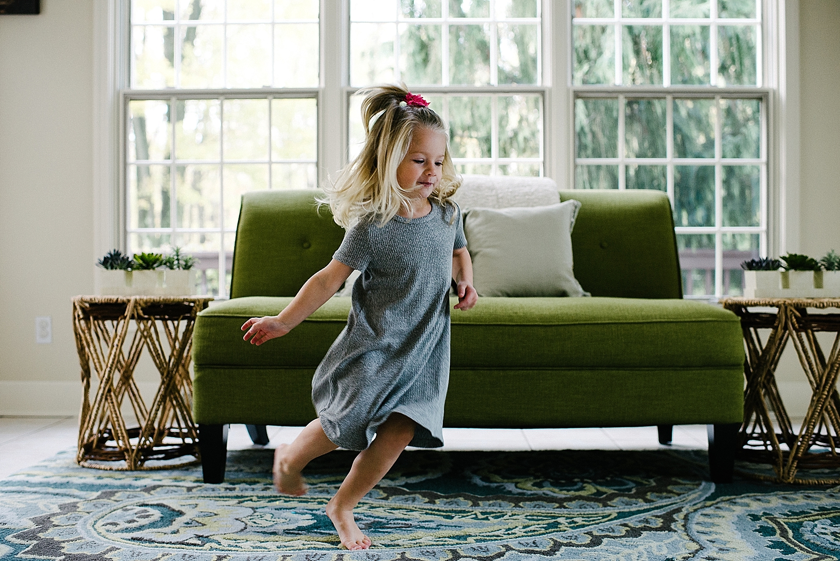 little girl dancing in sun room during home session