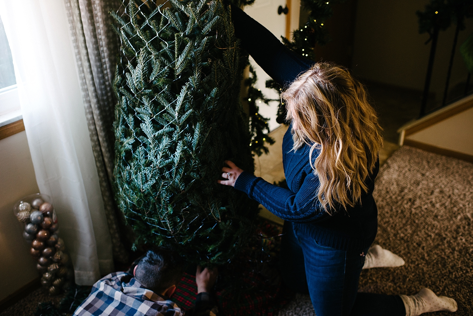 couple putting up Christmas tree in their home