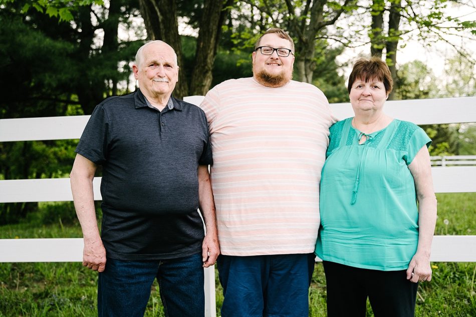 Mom and dad pose with their son during backyard generational session in ohio