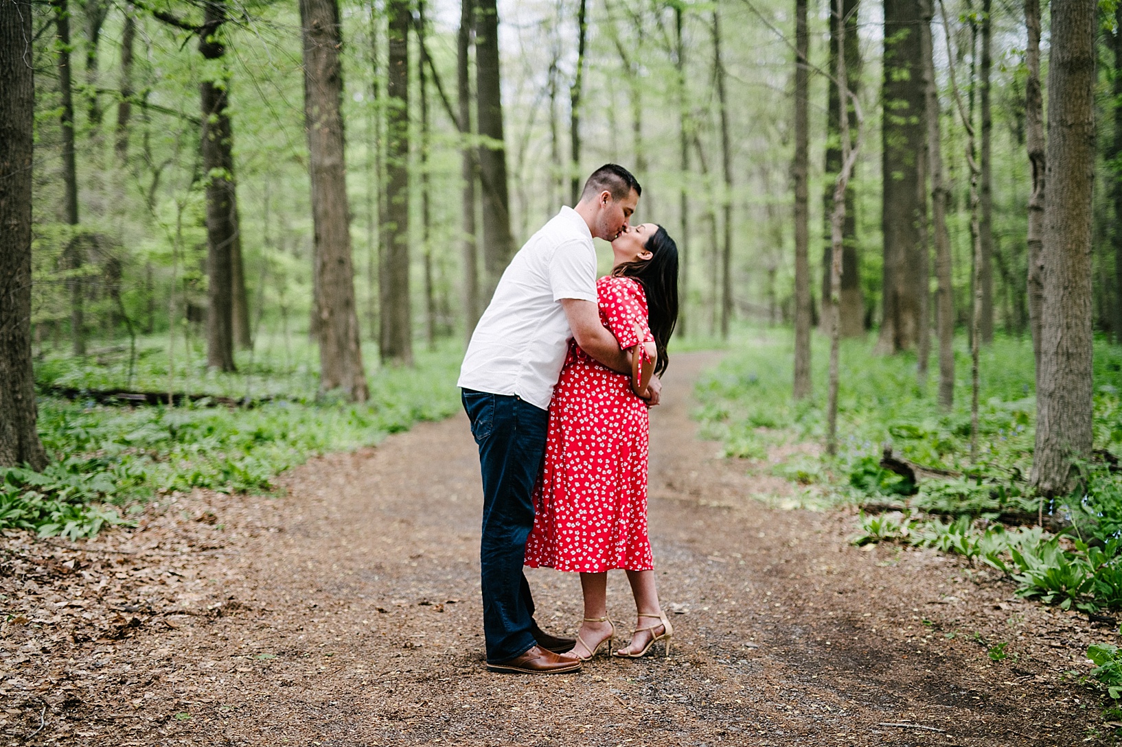 Couple kiss in the woods maternity photography shoot