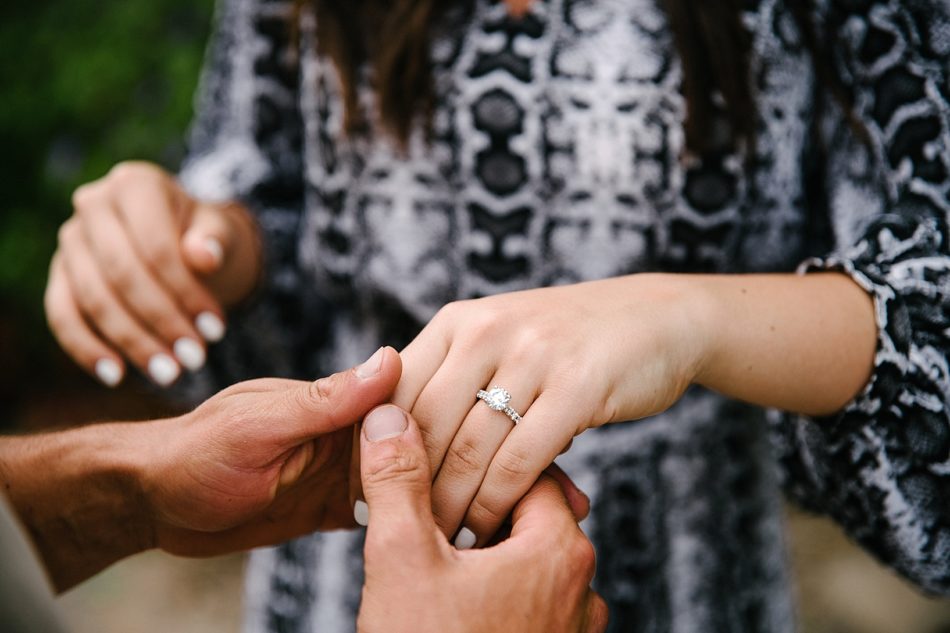 man holding fiance's hand with diamond ring on it