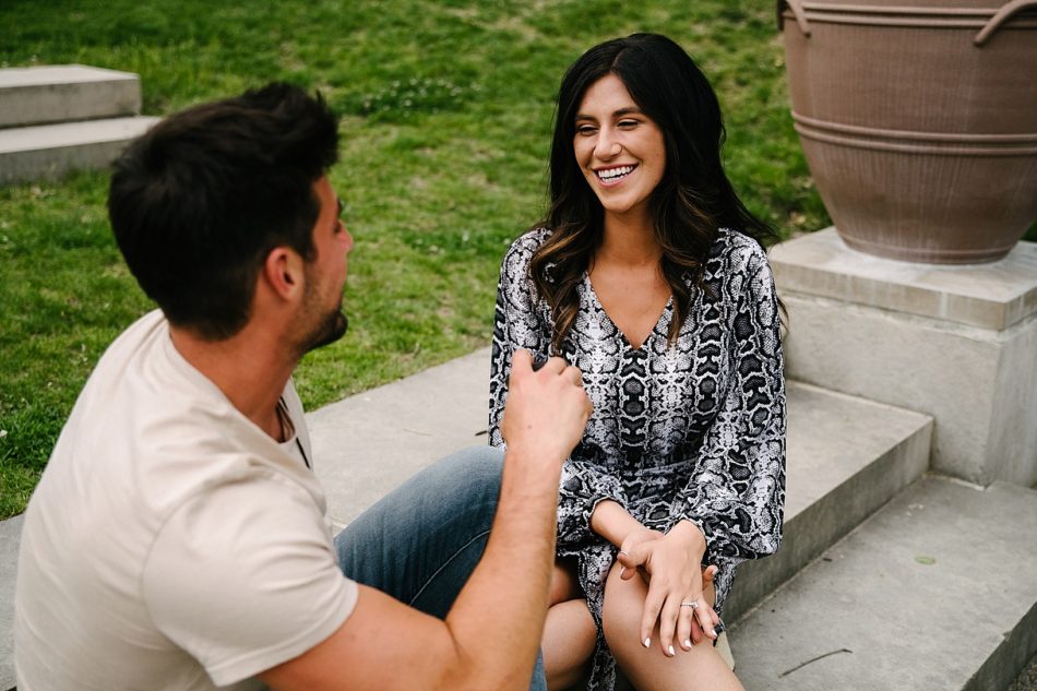 couple sitting on steps in Mellon Park after surprise proposal