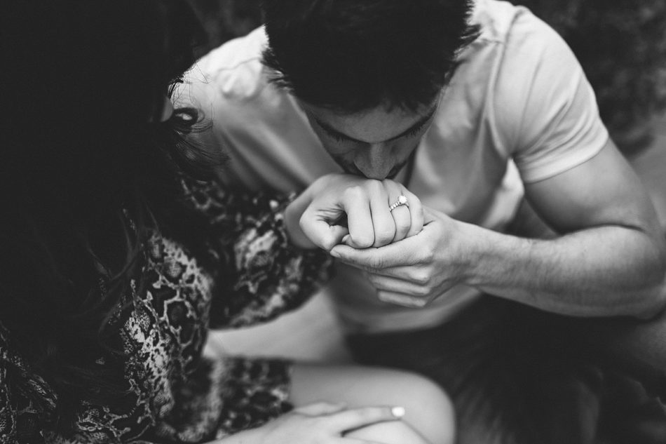 man kissing fiance's hand with diamond ring on it after proposing