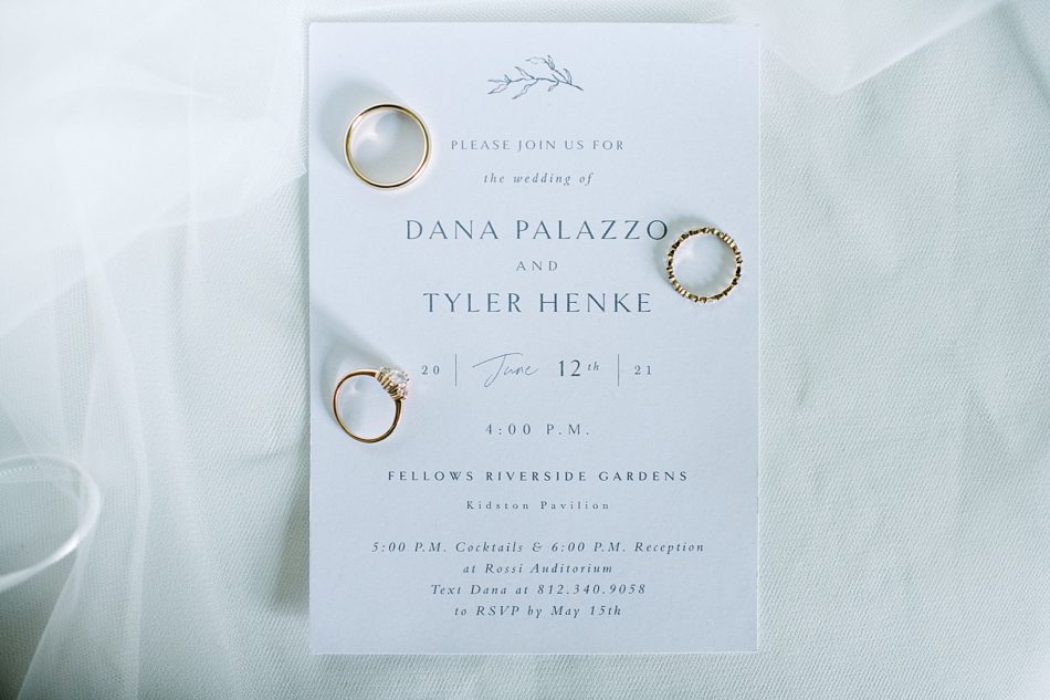 Photo of a wedding invite and gold wedding rings