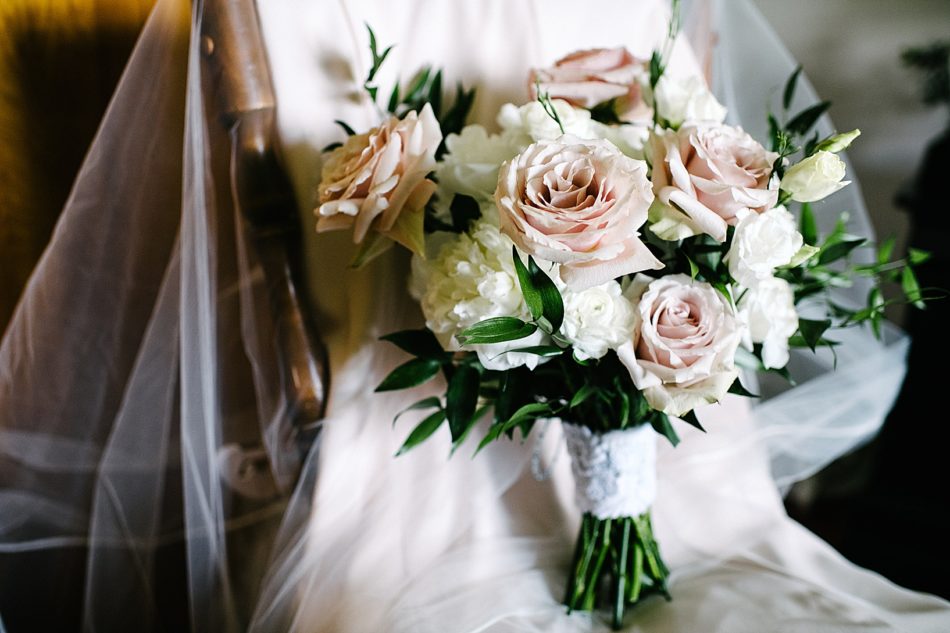 Bridal bouquet made of white and light pink roses and greenery
