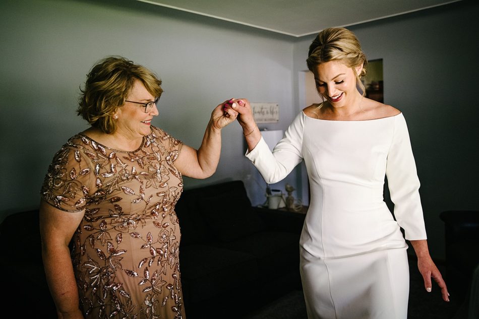 Mother in law holds bride's hand and smiles as she gets ready for ceremony