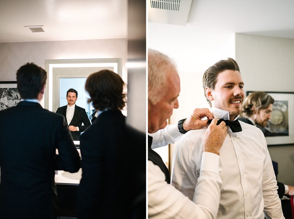 Father of the groom helps groom put bowtie on for ceremony