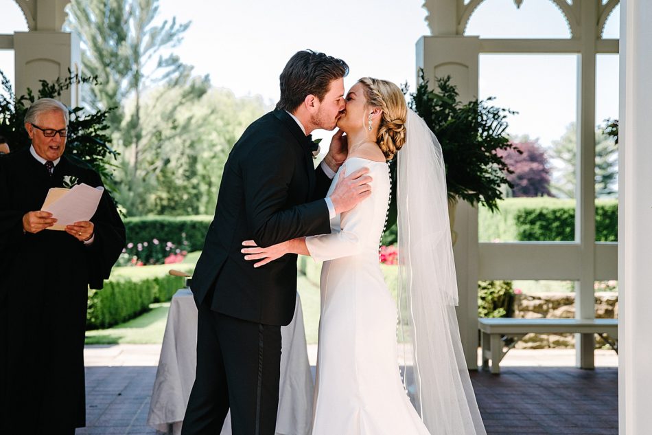 Bride and groom kiss at Kidston Pavilion at the Mill creek Park Fellows Riverside Gardens