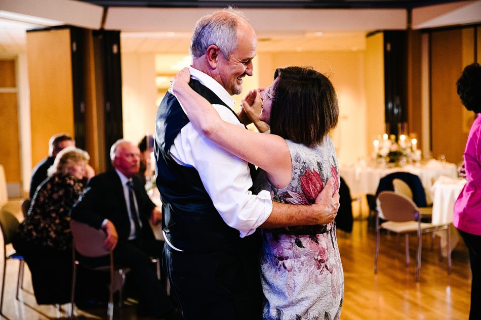 Older couple dances and smiles at each other during wedding