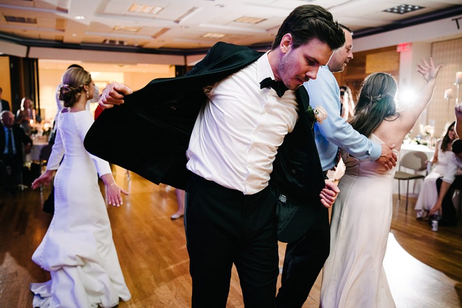 Groom dancing while holding open his suit jacket