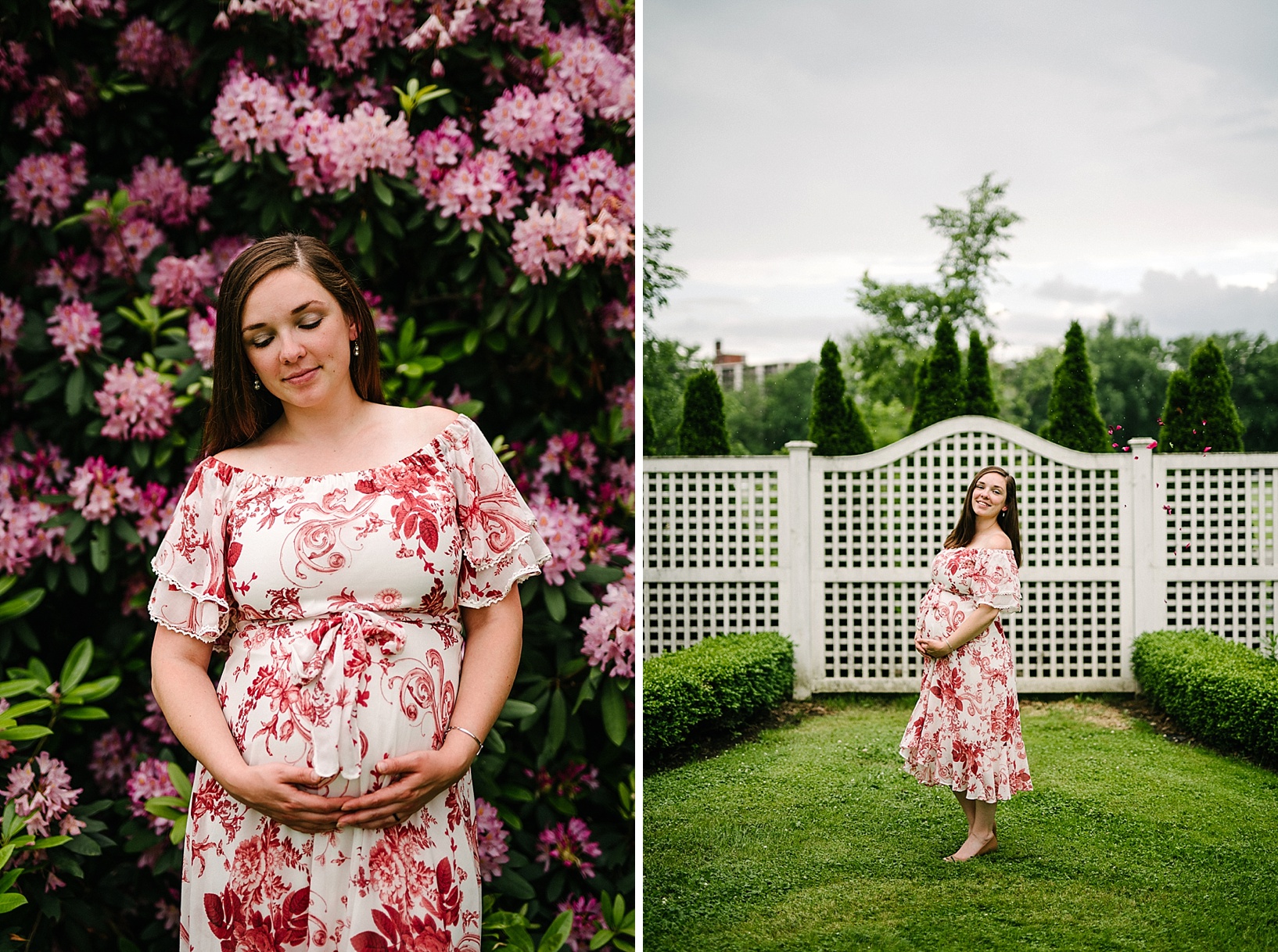 Pregnant woman in white and red floral dress holds her belly in front of a giant bush of pink flowers