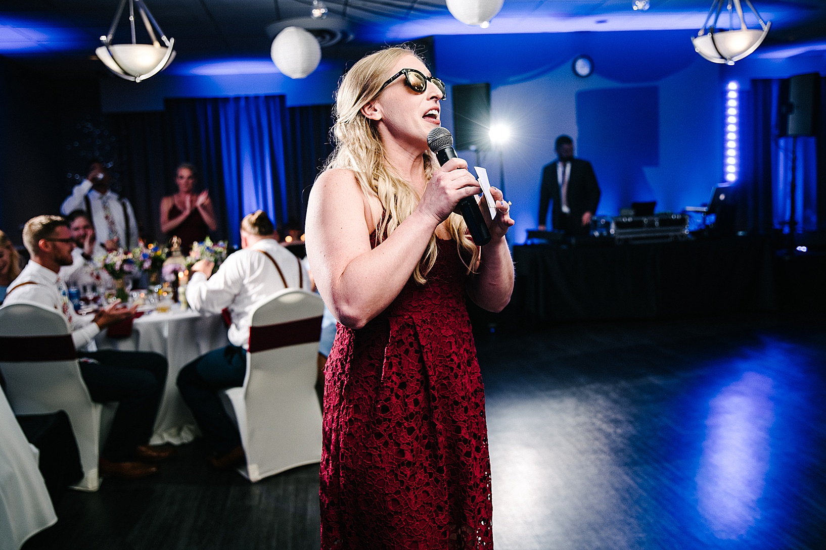 A bridesmaid giving a speech at the wedding wearing sunglasses in DiLucia's Banquet Hall