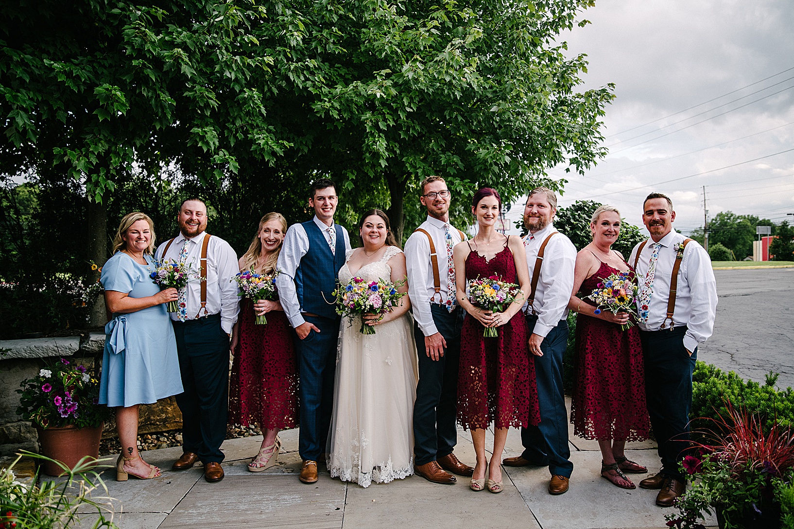 The whole wedding party lined up and posing for the camera with groom and bride in the middle