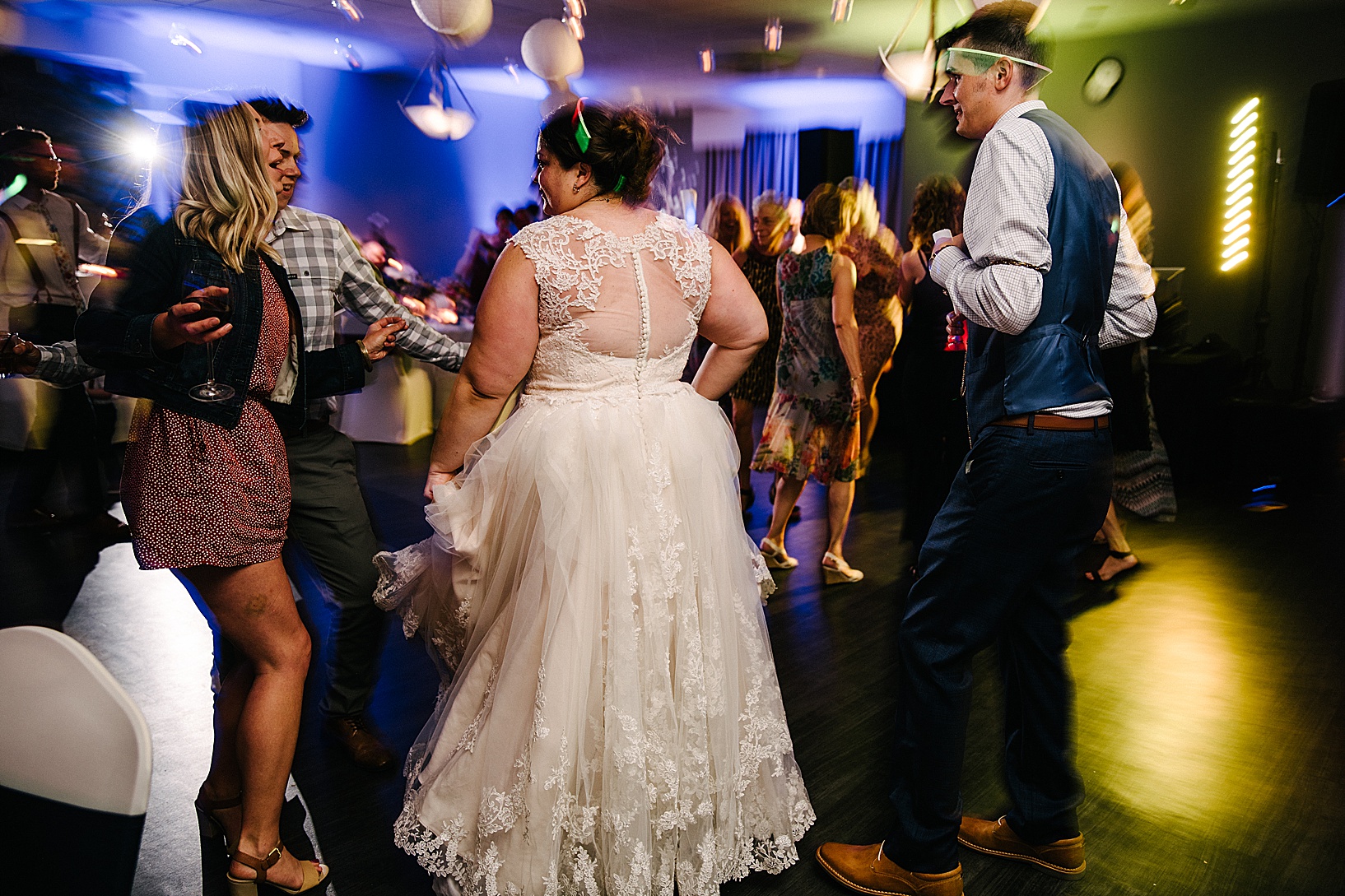 Bride on dance floor with guests with her back to the camera at post wedding celebration at DiLucia's Banquet Hall