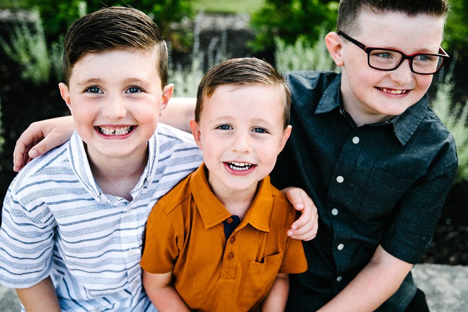 Three boys smile at camera.