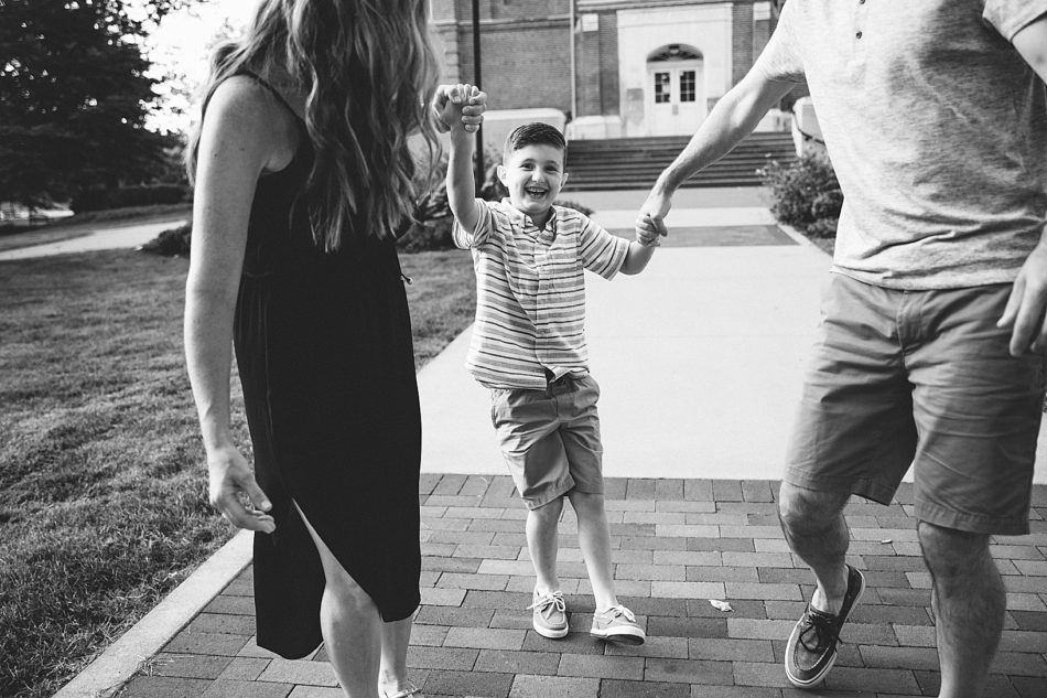 Mom and dad hold hands of son and walk together.