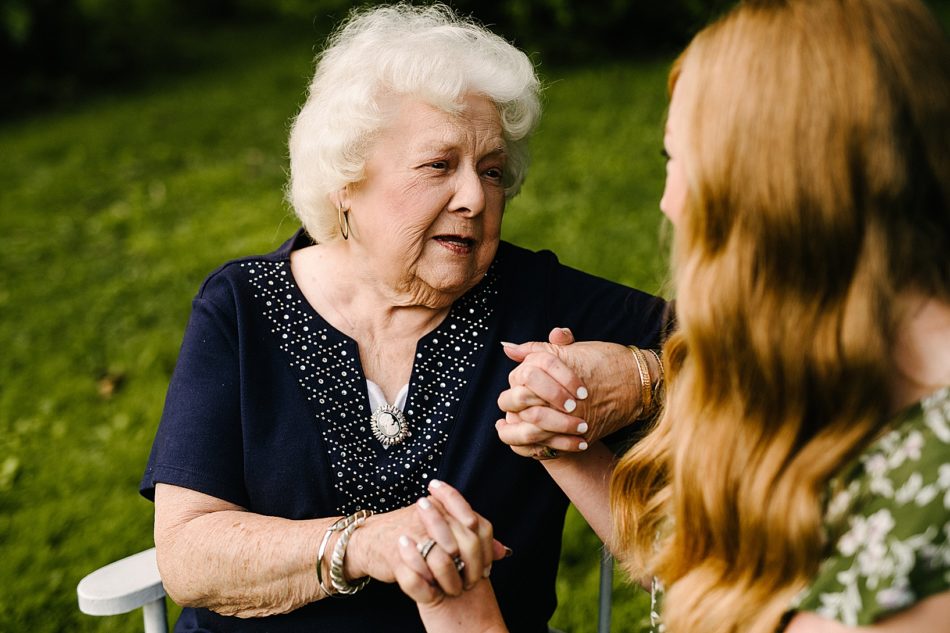 Grandmother holds granddaughters hands and looks into her eyes.