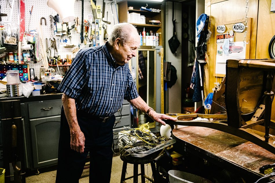 Grandfather admires a wooden chair he is working on in his tool shed at his home in East Liverpool. .