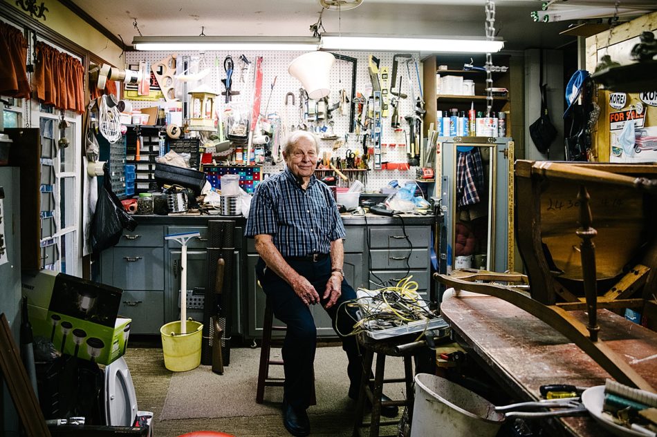 Grandfather poses and smiles in his tool shed with a wall of tools behind him at his home in East Liverpool.