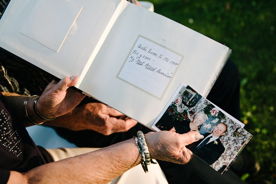 Grandmother holds an old photo of next to book that says "Poems to Me over the years, my most prized possessions".