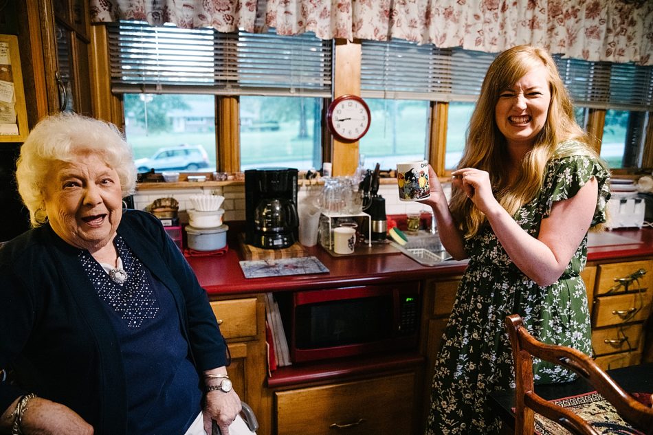 Granddaughter drinks coffee with grandmother in her kitchen in East Liverpool.
