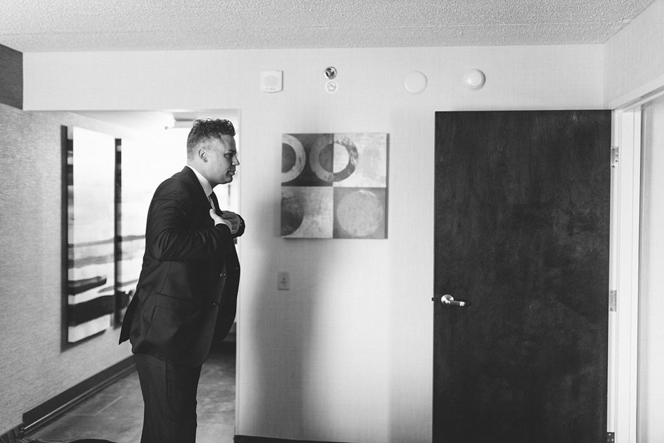 Groom putting his suit jacket on