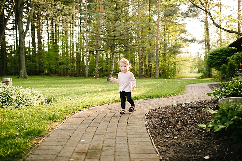 toddler girl running up brick path