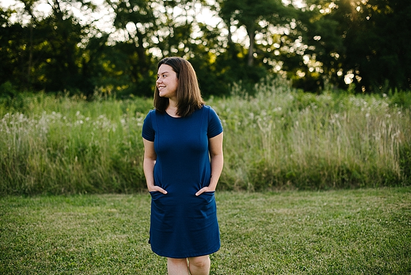 professional woman in blue dress standing by field