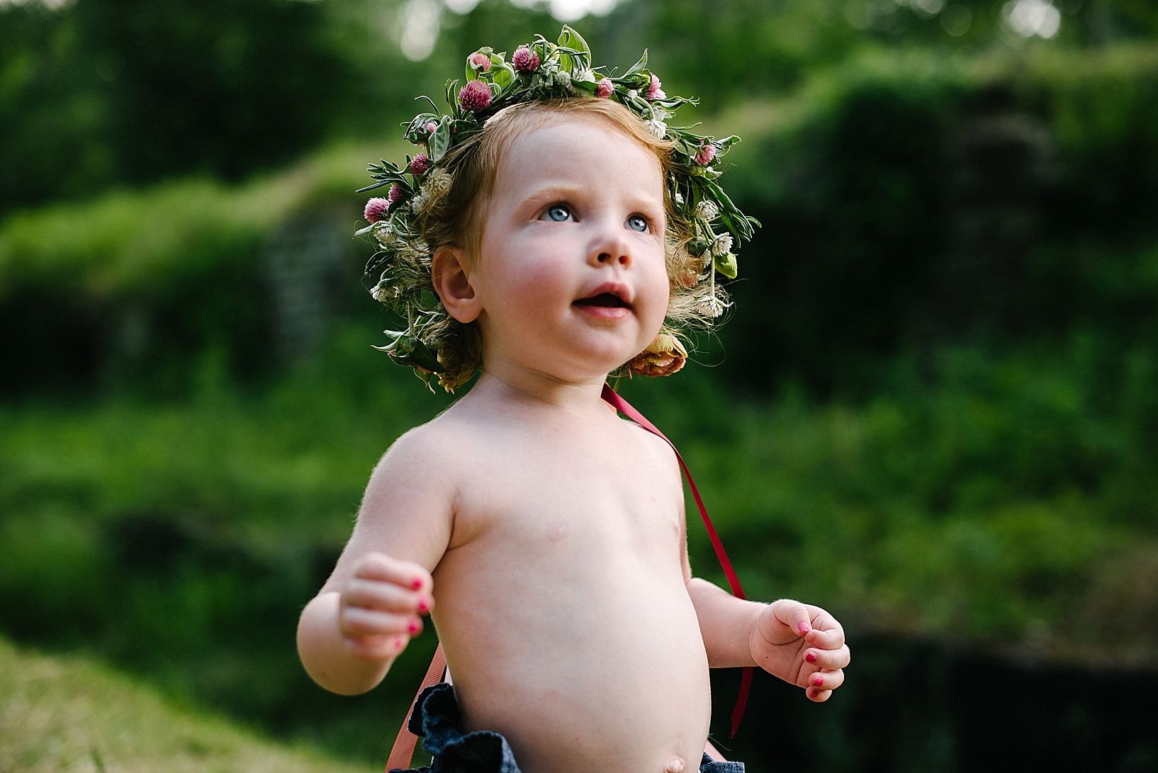 little girl with no shirt wearing floral crown