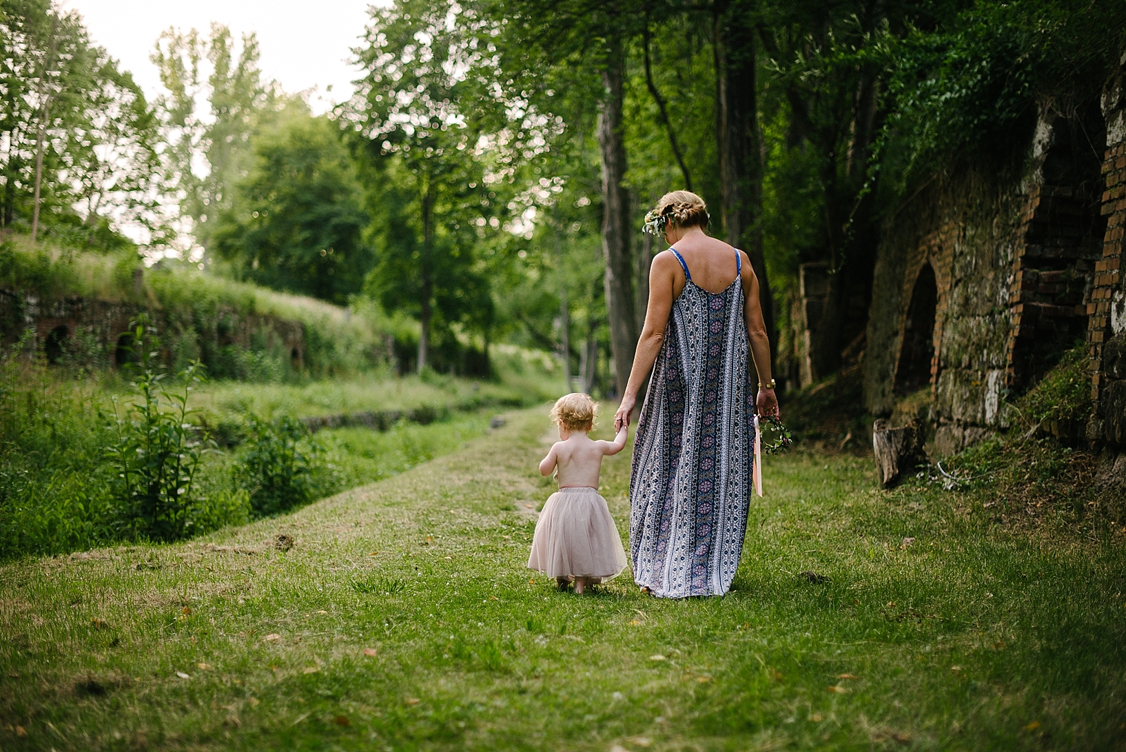 mother and daughter walking through woods