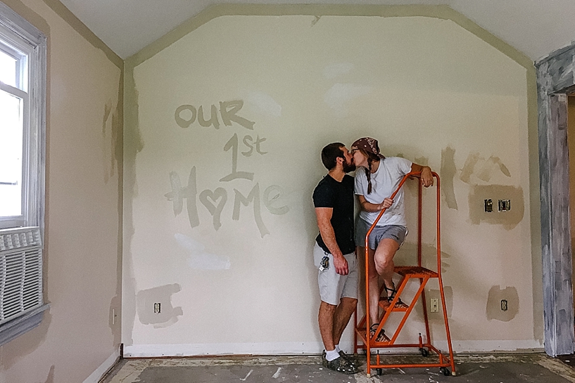 newlyweds kissing while painting living room